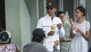 US President Barack Obama has shave ice with his daughter Malia (R) and friends at Island Snow in Kailua on January 1, 2015.  AFP PHOTO/NICHOLAS KAMM        (Photo credit should read NICHOLAS KAMM/AFP/Getty Images)