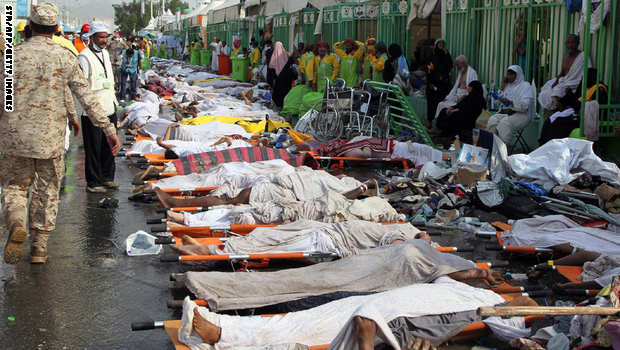 GRAPHIC CONTENT Saudi emergency personnel stand near bodies of Hajj pilgrims at the site where at least 717 were killed and hundreds wounded in a stampede in Mina, near the holy city of Mecca, at the annual hajj in Saudi Arabia on September 24, 2015. The stampede, the second deadly accident to strike the pilgrims this year, broke out during the symbolic stoning of the devil ritual, the Saudi civil defence service said. AFP PHOTO / STR (Photo credit should read STR/AFP/Getty Images)
