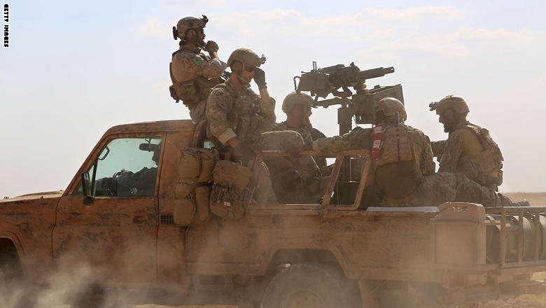 TOPSHOT - Armed men in uniform identified by Syrian Democratic forces as US special operations forces ride in the back of a pickup truck in the village of Fatisah in the northern Syrian province of Raqa on May 25, 2016.  US-backed Syrian fighters and Iraqi forces pressed twin assaults against the Islamic State group, in two of the most important ground offensives yet against the jihadists. The Syrian Democratic Forces (SDF), formed in October 2015, announced on May 24 its push for IS territory north of Raqa city, which is around 90 kilometres (55 miles) south of the Syrian-Turkish border and home to an estimated 300,000 people. The SDF is dominated by the Kurdish People's Protection Units (YPG) -- largely considered the most effective independent anti-IS force on the ground in Syria -- but it also includes Arab Muslim and Christian fighters.  / AFP / DELIL SOULEIMAN        (Photo credit should read DELIL SOULEIMAN/AFP/Getty Images)